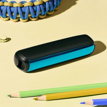 Prim-plan al accesoriului capac frontal Ploom AURA Ocean Blue pe birou.